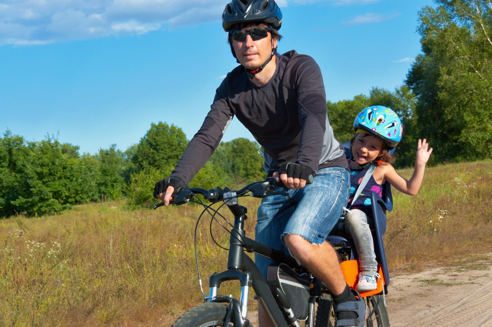 Father with kid riding bicycle outdoors